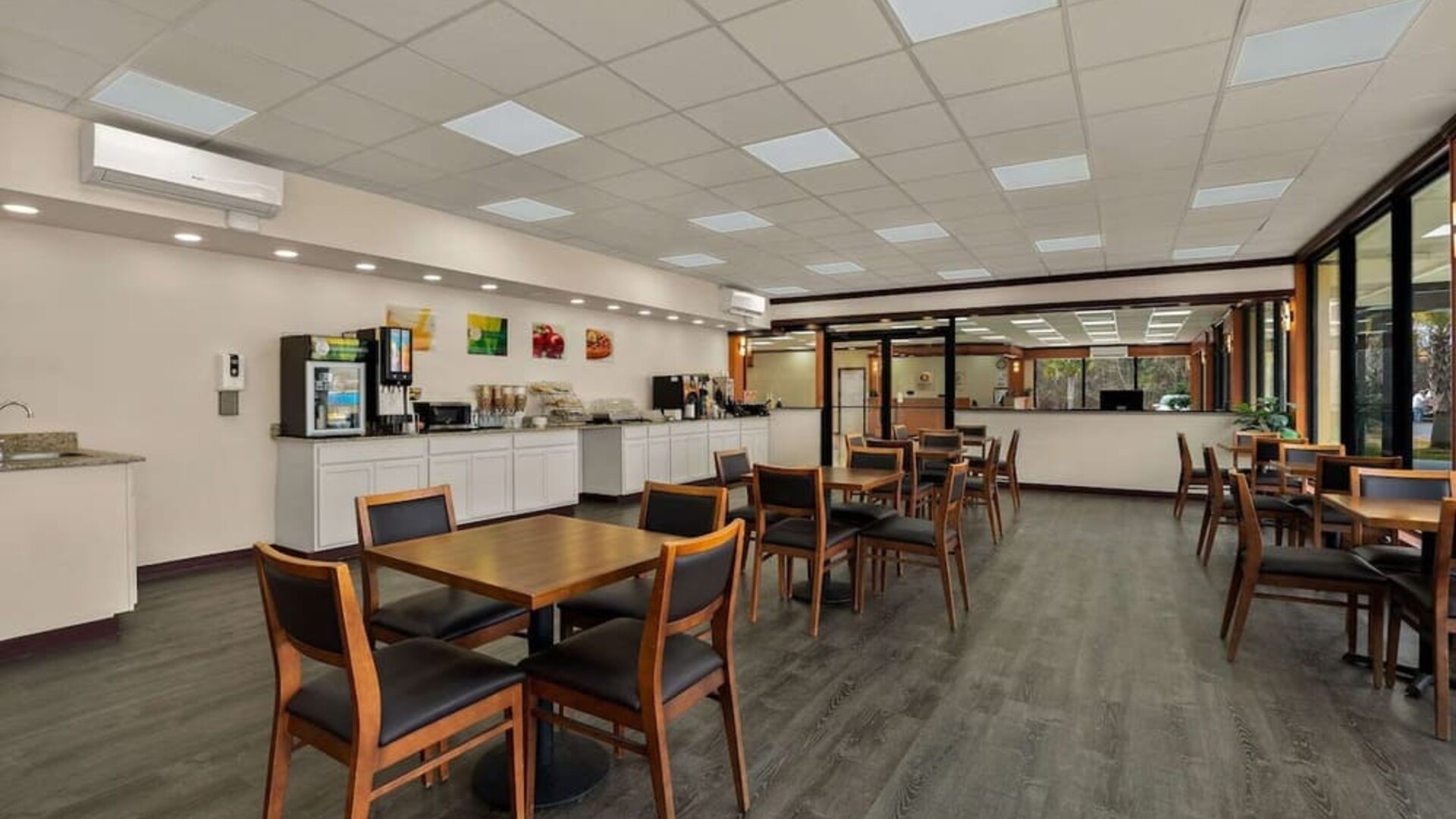 Breakfast dining area with wooden tables, buffet station and large windows overlooking the grounds at Econo Lodge Yemassee.