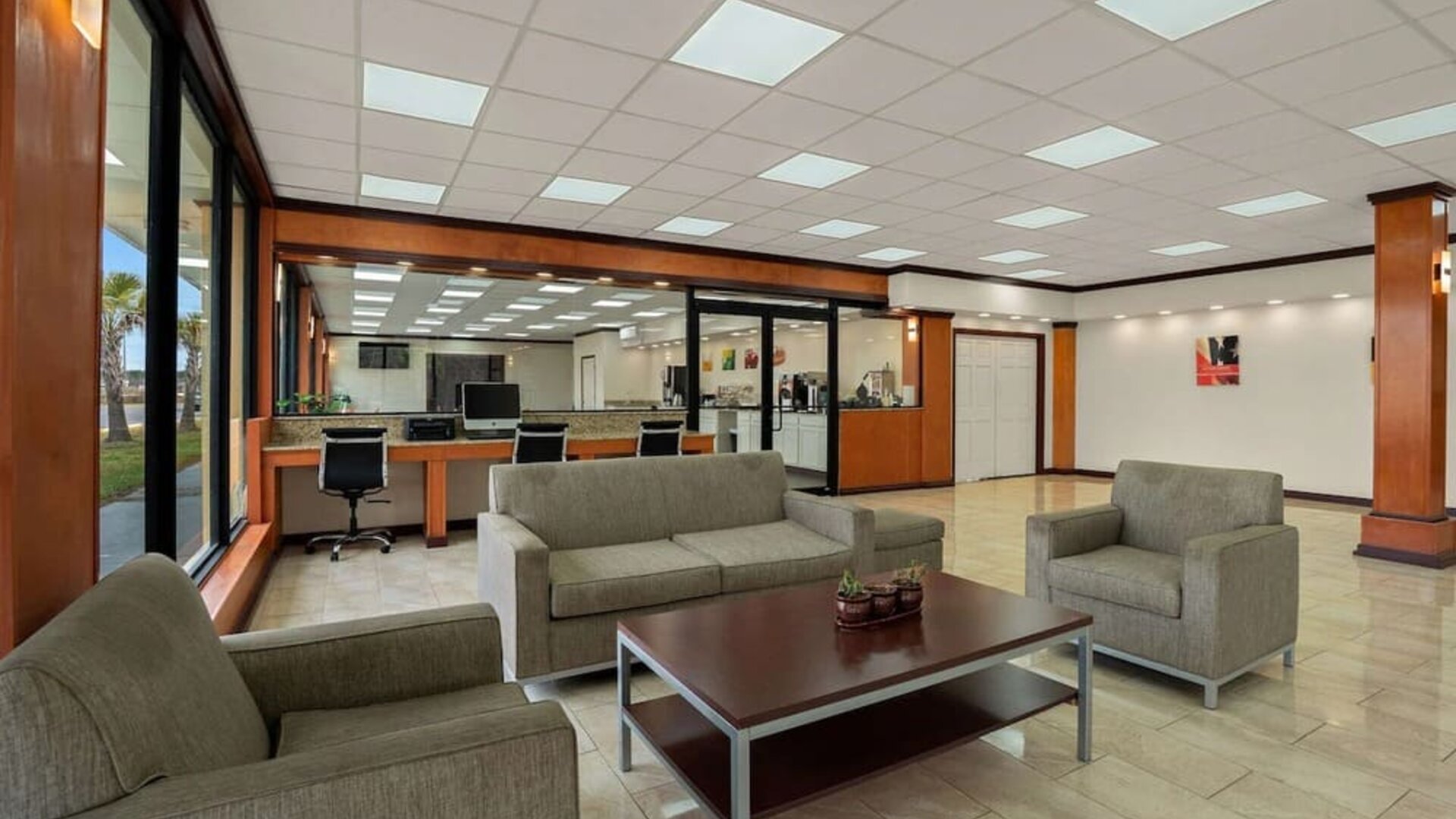 Open lobby seating area with business center workstations, sofas and tiled flooring at Econo Lodge Yemassee.