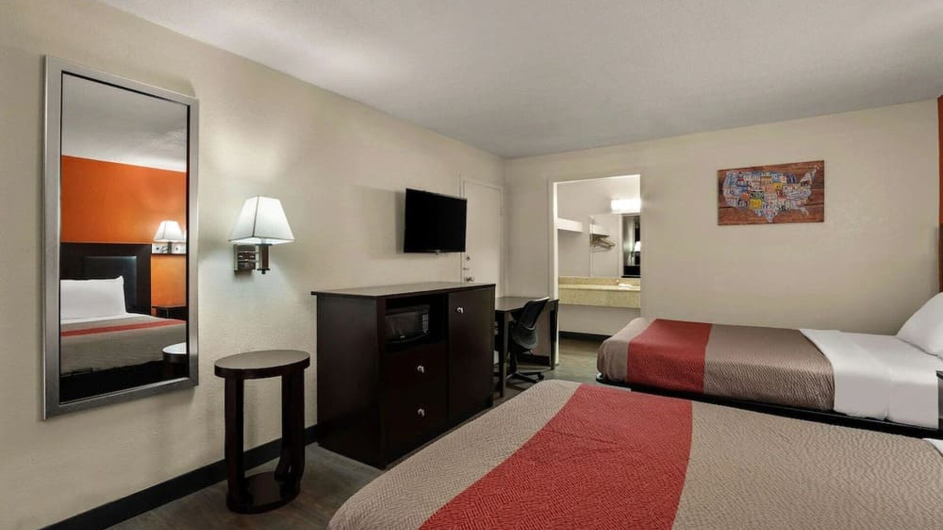 Guest room with two double beds, wall-mounted TV, microwave and workspace at Econo Lodge Yemassee.