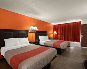Guest room with two double beds, orange accent wall and exterior entry door at Econo Lodge Yemassee.