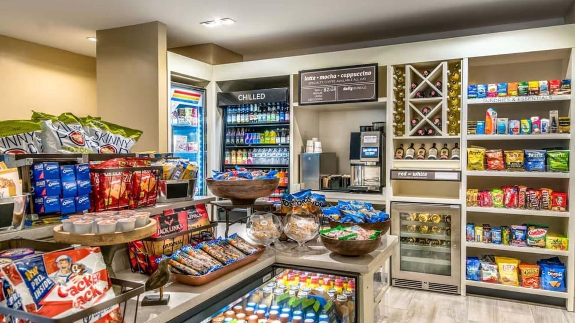 Hotel market stocked with snacks, cold drinks, wine, convenience items, coffee, and grab-and-go refreshments.