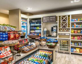Hotel market stocked with snacks, cold drinks, wine, convenience items, coffee, and grab-and-go refreshments.