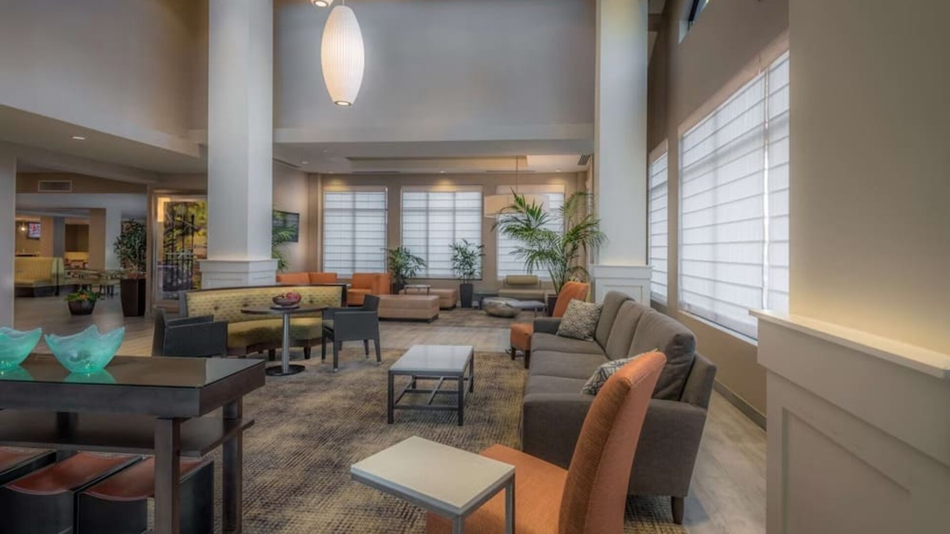 Spacious hotel lobby with comfortable seating, high ceilings, natural light, and relaxing areas for work or conversation.