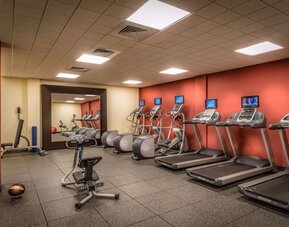 On-site fitness center featuring treadmills, elliptical machines, stationary bike, free weights, and exercise equipment.