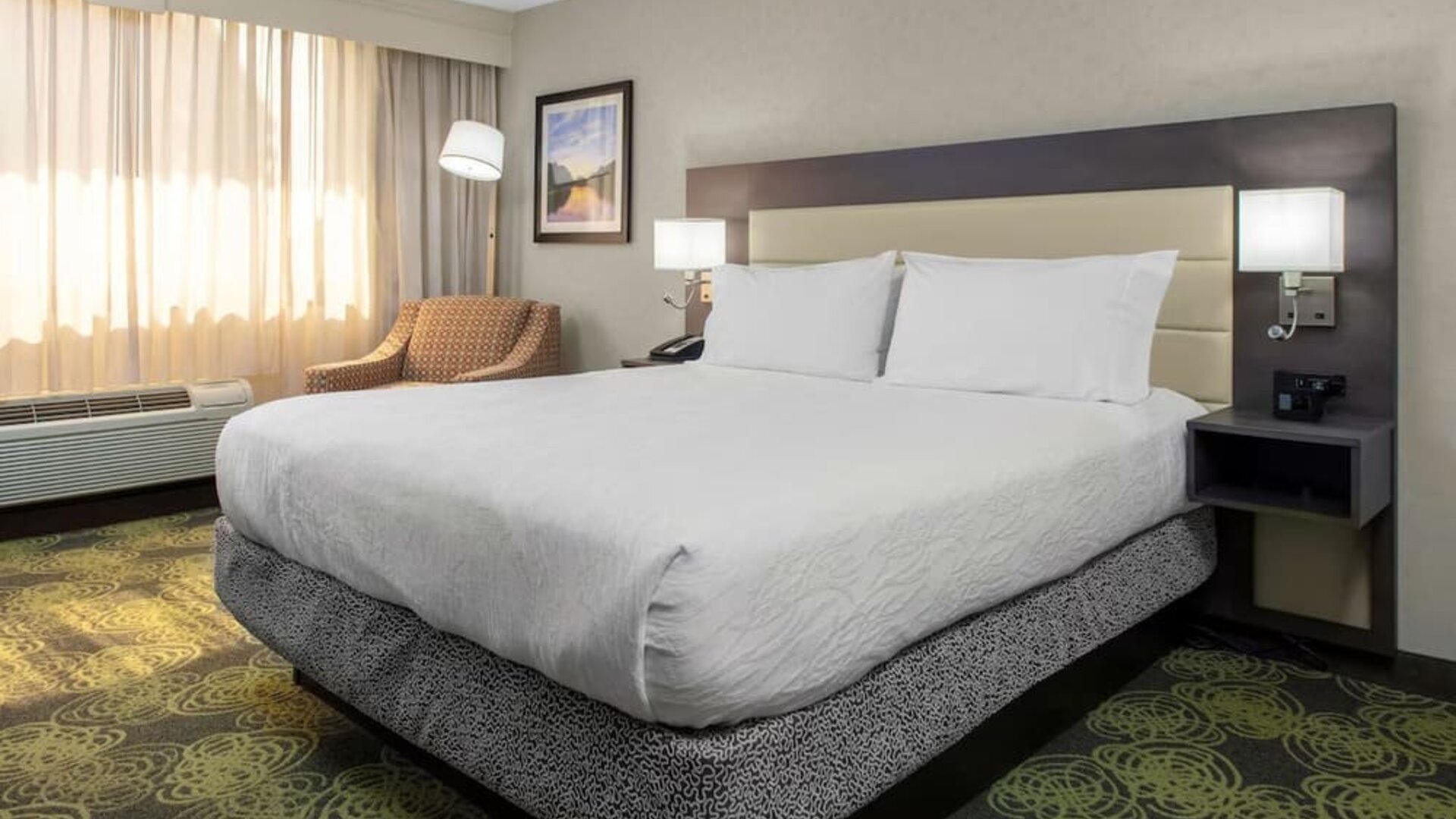 Spacious king suite with separate bedroom, living area, HDTV, work desk, microwave, and comfortable seating.