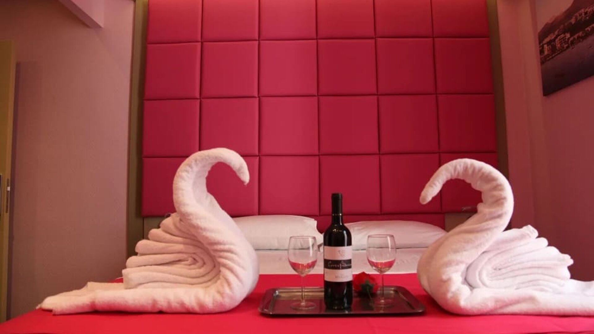 Romantic double room with padded headboard, towel swans and complimentary wine at Dolce Vita Rooms & Breakfast.