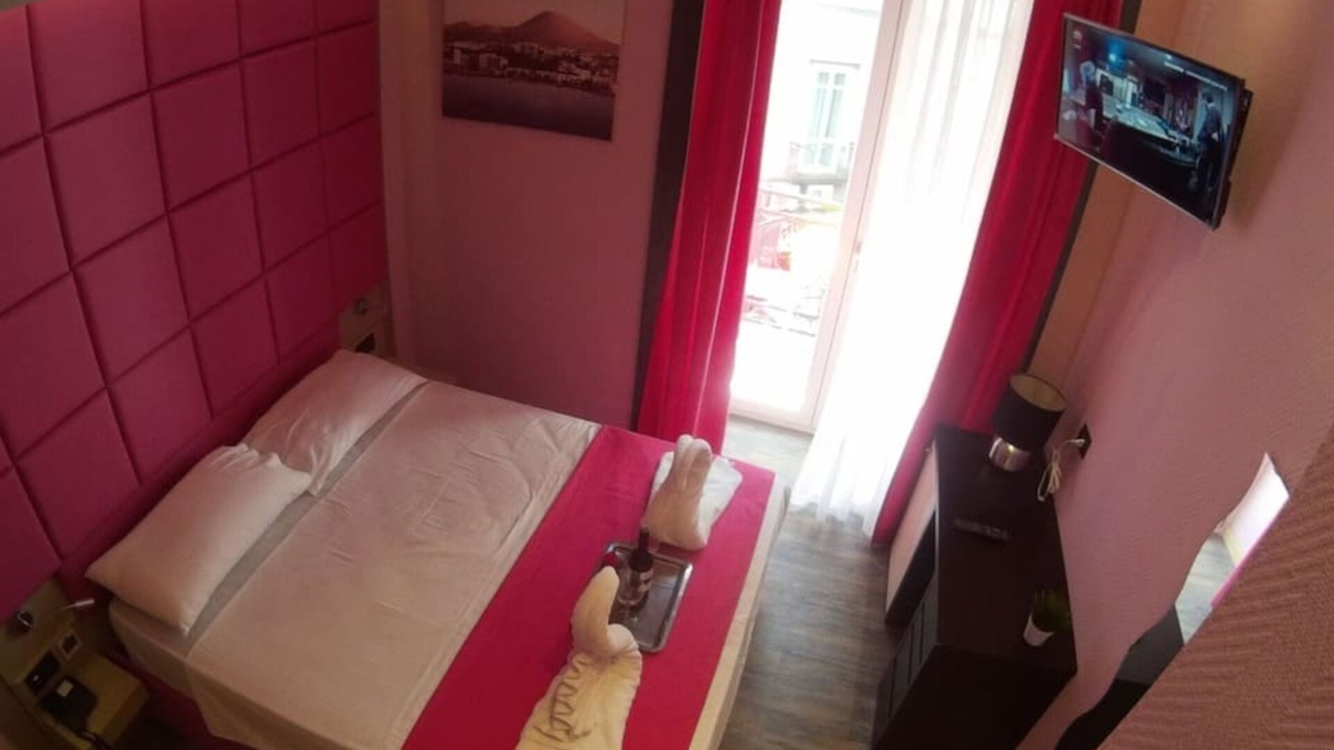 Bright double room with balcony access, flat-screen TV and modern décor at Dolce Vita Rooms & Breakfast.