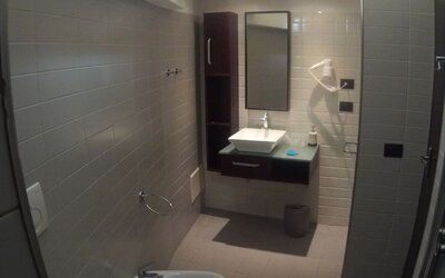 Modern bathroom with glass-enclosed shower, bidet and contemporary vanity at Dolce Vita Rooms & Breakfast.