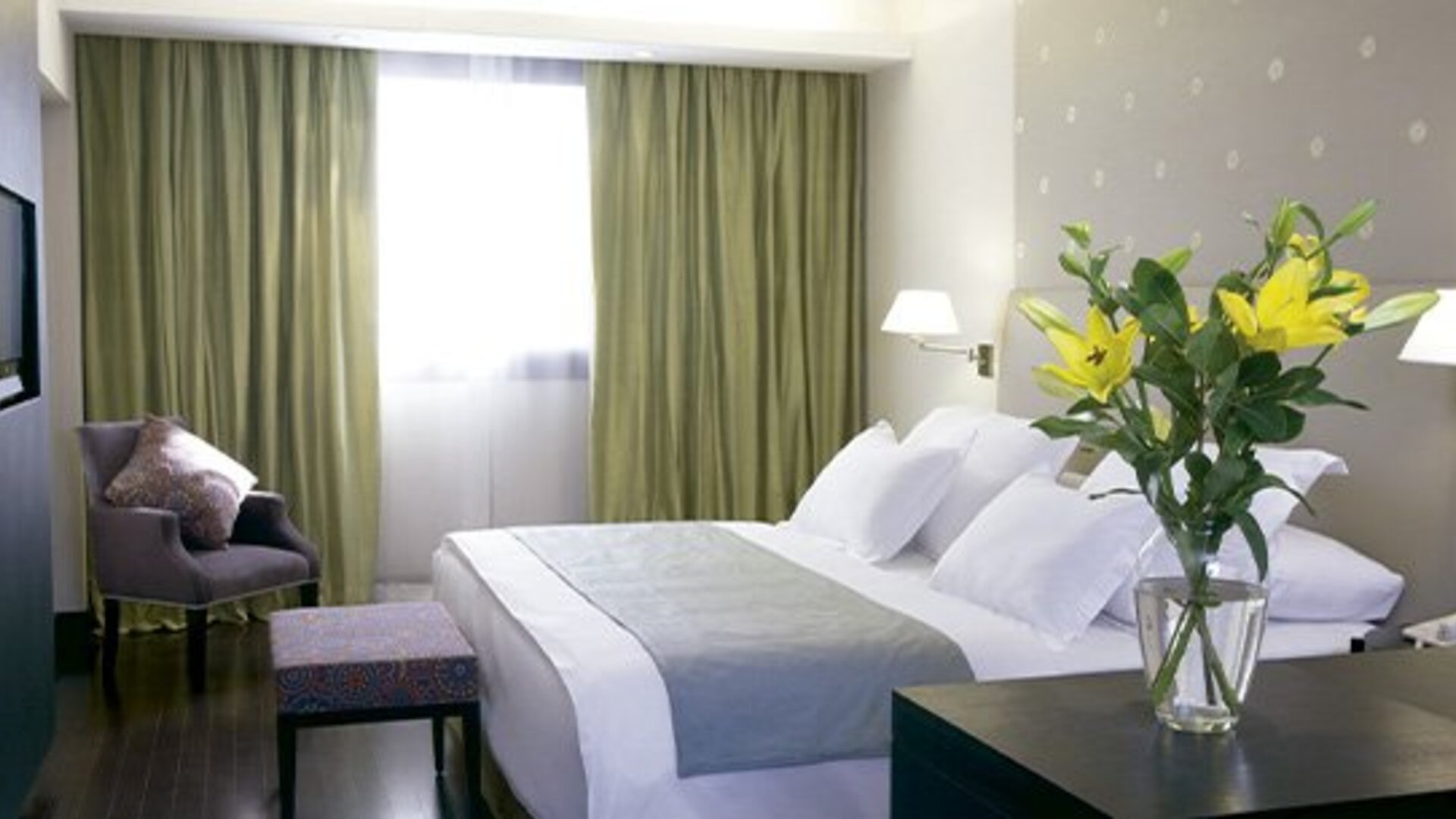 Spacious guest room with king bed, seating area, work space and large window at NH Buenos Aires 9 De Julio.