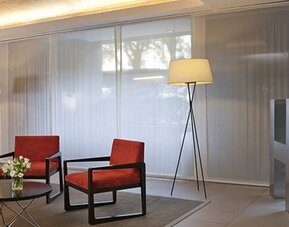 Stylish hotel lobby with comfortable lounge seating, floor-to-ceiling windows and modern décor at NH Buenos Aires 9 De Julio.