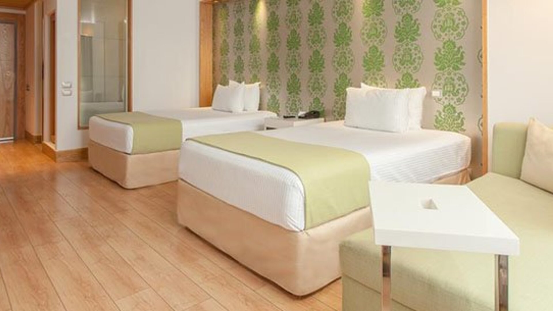 Contemporary guest room with two double beds, sofa seating and modern amenities at NH Collection Mexico City Airport T2.