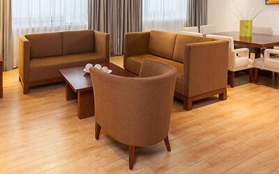 Spacious suite living area with comfortable sofas, dining table and contemporary furnishings at NH Collection Mexico City Airport T2.