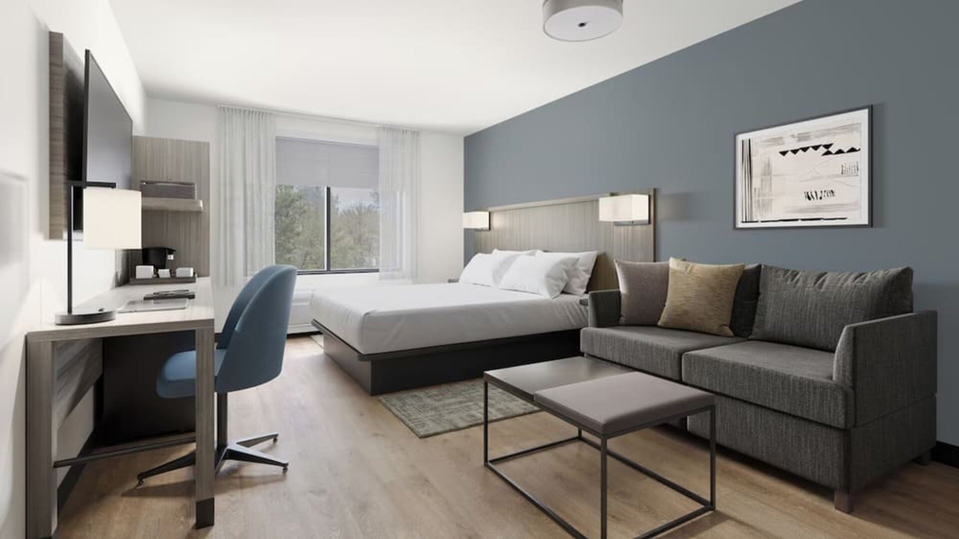 Studio-style guest room featuring a king bed, sofa, coffee table and dedicated workspace at Hyatt Select Philadelphia Airport.