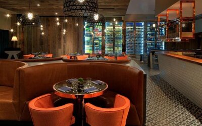 Stylish hotel restaurant with warm wood accents, cozy booth seating and illuminated wine displays at Royal Sonesta Minneapolis.