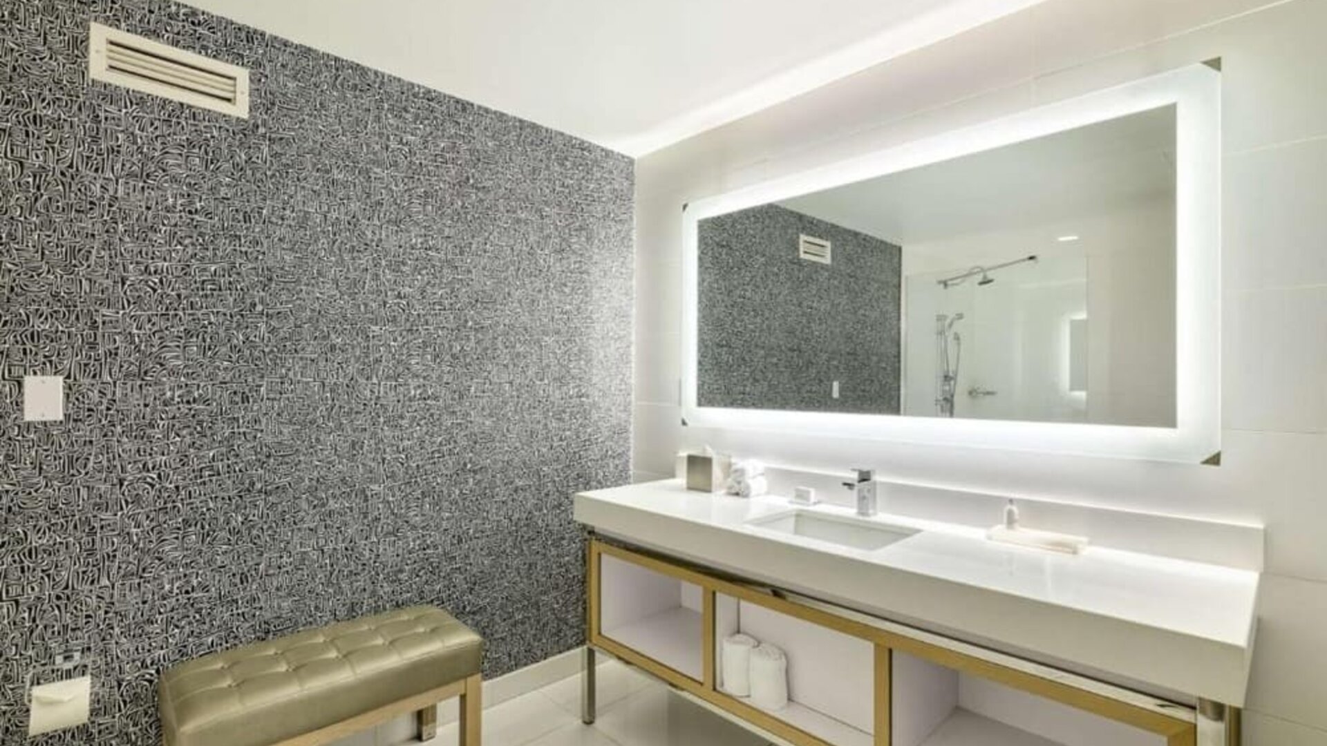 Spacious guest bathroom featuring a double vanity, illuminated mirror and modern walk-in shower at Royal Sonesta Minneapolis.