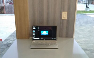 Business center at Days Inn & Suites By Wyndham Downtown/University Of Houston featuring a laptop workstation beside large windows.