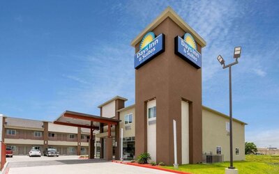 Exterior view of Days Inn & Suites By Wyndham Downtown/University Of Houston featuring the hotel building, entrance and branded signage.