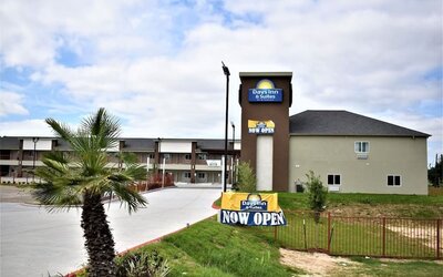 Exterior view of Days Inn & Suites By Wyndham Downtown/University Of Houston featuring the hotel building and prominent roadside signage.