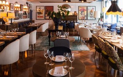 Restaurant at Hotel Pulitzer Buenos Aires featuring elegant table settings, stylish seating and eclectic wall décor.