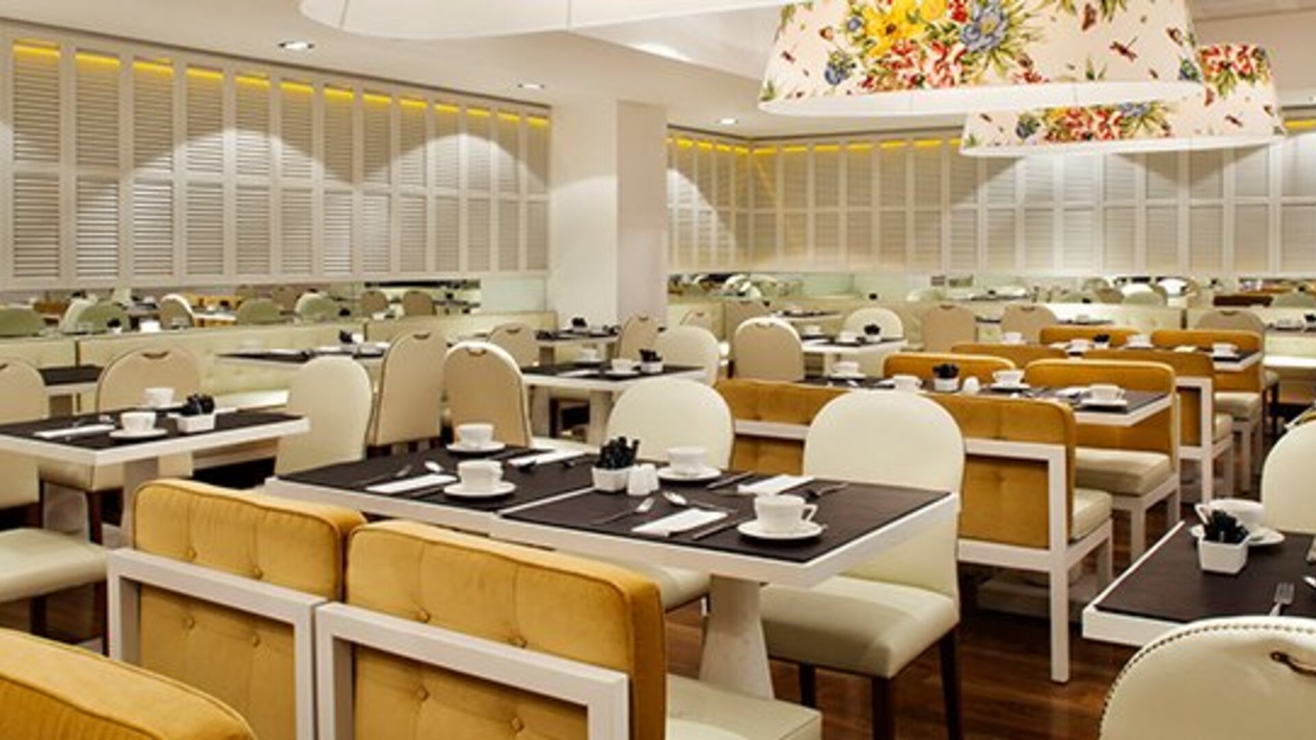 Dining area at Hotel Pulitzer Buenos Aires featuring neatly arranged tables, upholstered seating and contemporary overhead lighting.