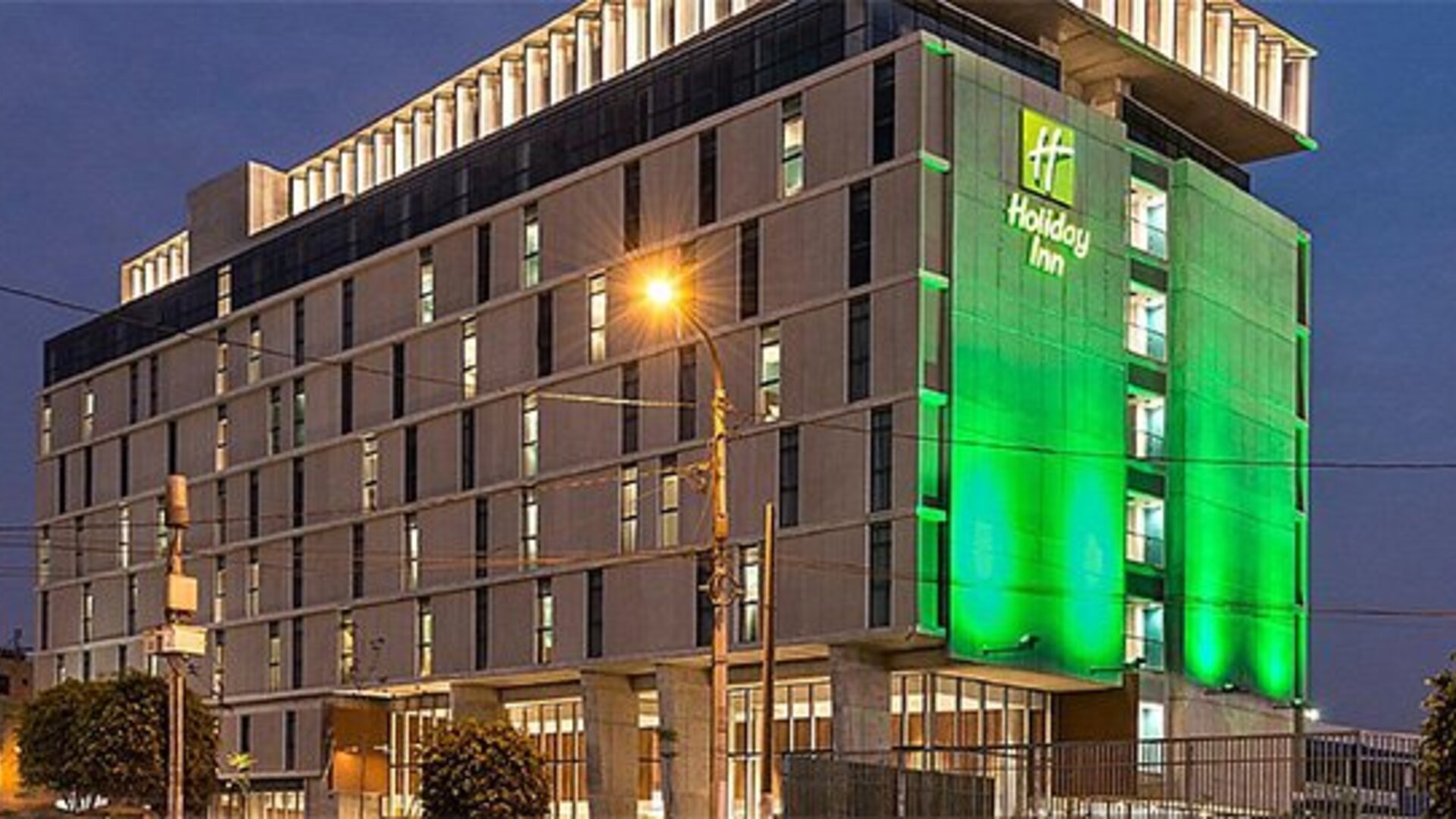 Exterior view of Holiday Inn Lima Airport featuring the multi-story hotel building illuminated at night.