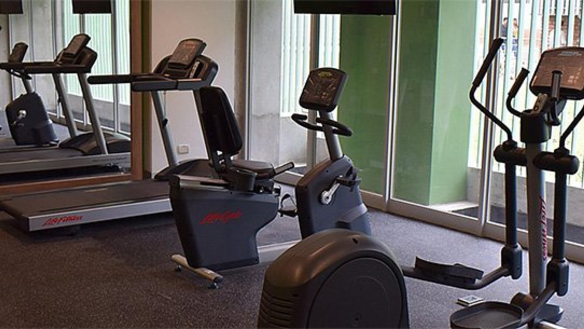 Fitness center at Holiday Inn Lima Airport featuring treadmills, stationary bikes, elliptical machines and mirrored walls.