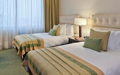 Guest room at Hotel Marquis Reforma featuring two beds, upholstered headboards, bedside lighting and contemporary décor.