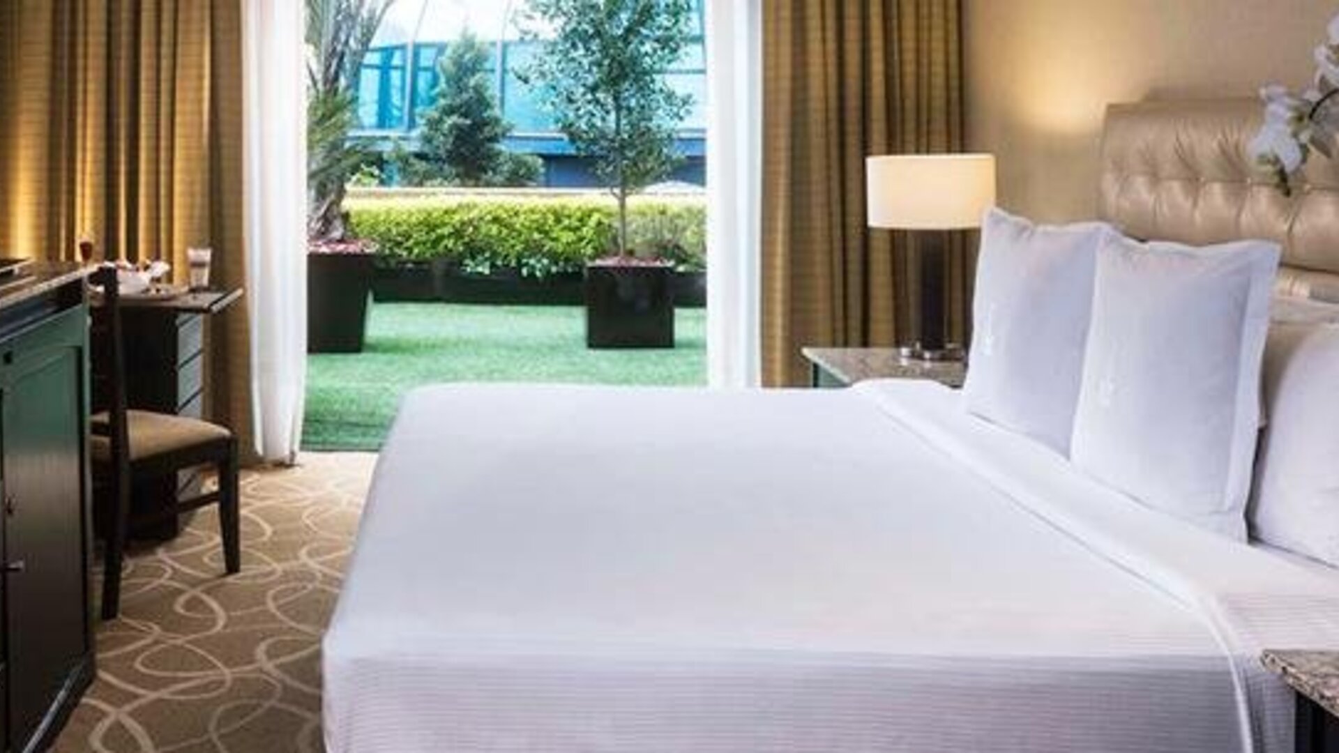 Guest room at Hotel Marquis Reforma featuring a large bed, work desk and access to a private outdoor terrace.