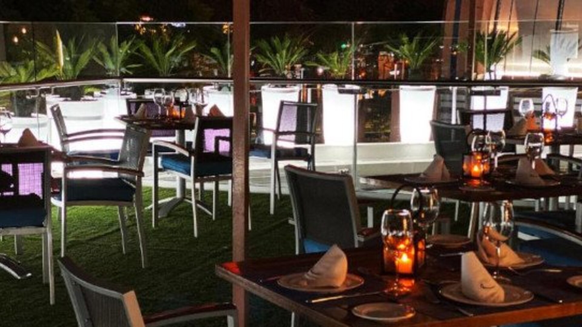 Outdoor dining terrace at Hotel Marquis Reforma featuring set tables, contemporary seating and ambient evening lighting.