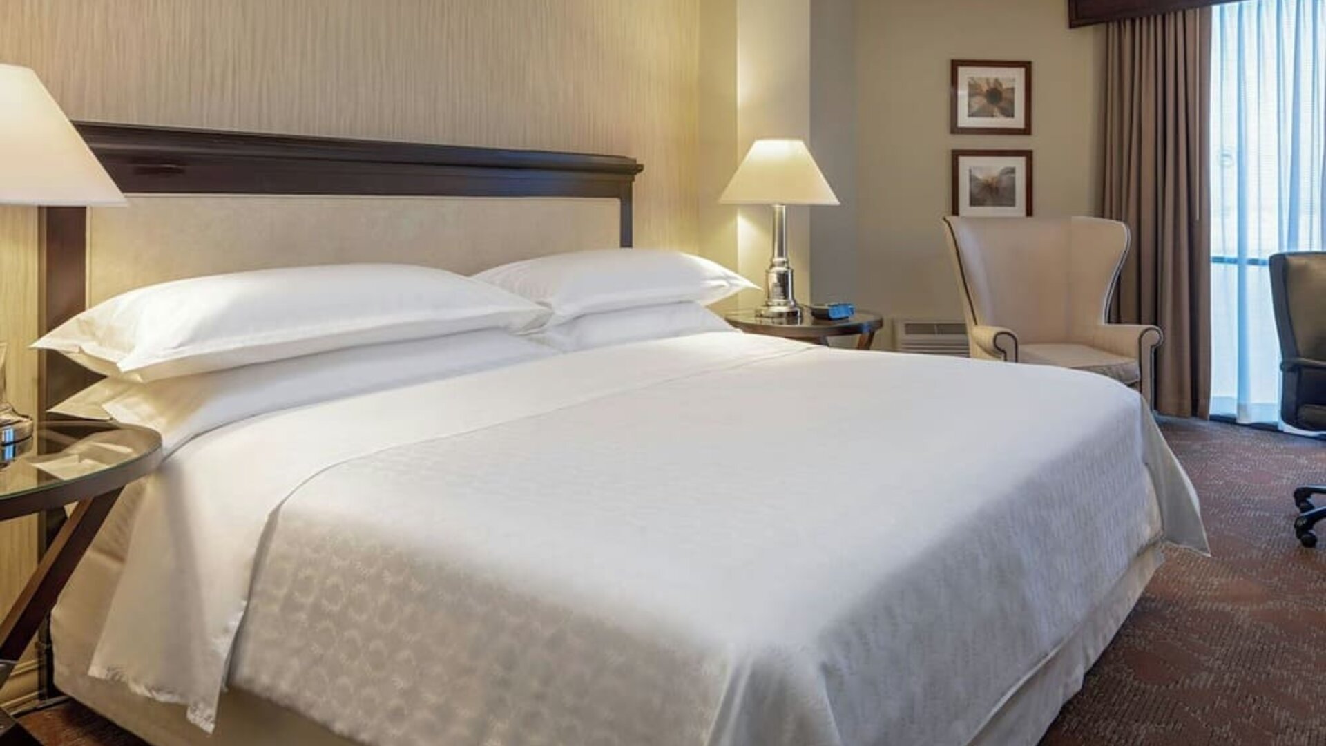 Comfortable guest room featuring a king-size bed, plush seating and a dedicated workspace at Sheraton Houston Brookhollow Hotel.