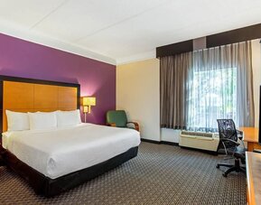 Comfortable guest room featuring a king-size bed, a dedicated workspace and contemporary décor at La Quinta Inn & Suites By Wyndham Orlando I Drive/Conv Ctr.