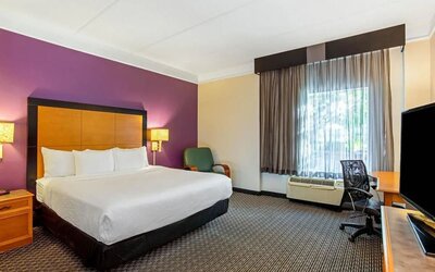 Comfortable guest room featuring a king-size bed, a dedicated workspace and contemporary décor at La Quinta Inn & Suites By Wyndham Orlando I Drive/Conv Ctr.