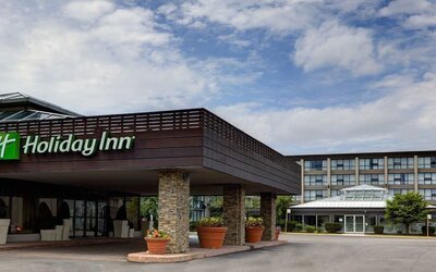Covered hotel entrance featuring stone columns, landscaped planters and convenient drop-off access at Holiday Inn Toronto Airport East.