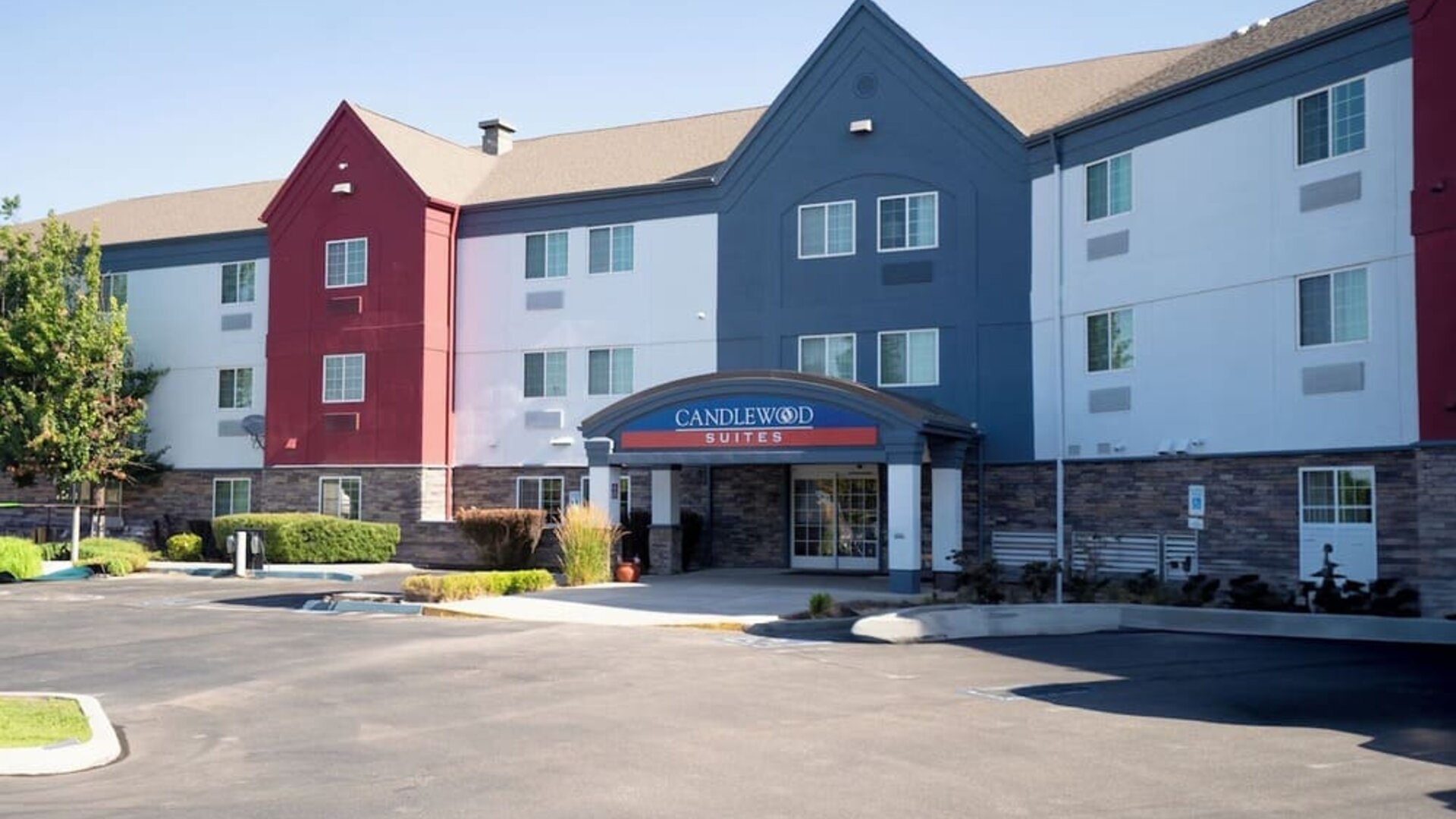 Modern bathroom featuring a spacious vanity, illuminated mirror and a glass-enclosed shower at Candlewood Suites Boise.