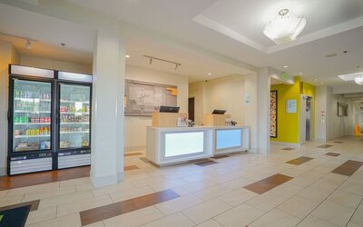 Reception area featuring a modern front desk, a grab-and-go market and bright, welcoming décor at Holiday Inn Express & Suites Ontario.