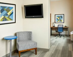 In-room workspace featuring a dedicated desk, comfortable seating and a separate work area within the guest suite at Holiday Inn Express & Suites Ontario.