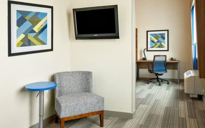 In-room workspace featuring a dedicated desk, comfortable seating and a separate work area within the guest suite at Holiday Inn Express & Suites Ontario.