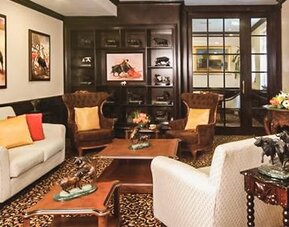 Private lounge featuring sofas, armchairs, handcrafted furnishings, artwork, and traditional Mexican-inspired décor at Hotel Geneve.