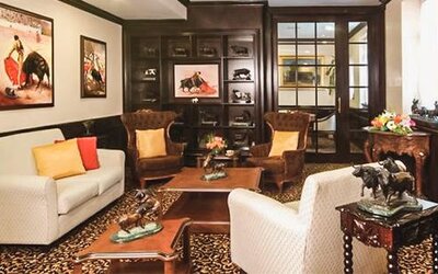 Private lounge featuring sofas, armchairs, handcrafted furnishings, artwork, and traditional Mexican-inspired décor at Hotel Geneve.
