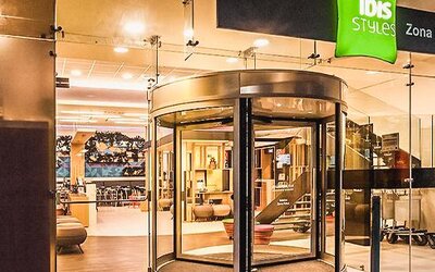 Glass entrance with revolving doors, contemporary lighting, and a welcoming reception area at Ibis Styles Mexico Reforma.