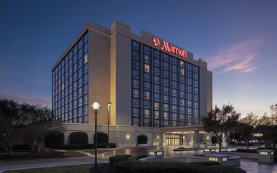 Exterior view showcasing the hotel's contemporary architecture, landscaped grounds, and covered entrance at Houston Marriott South at Hobby Airport.