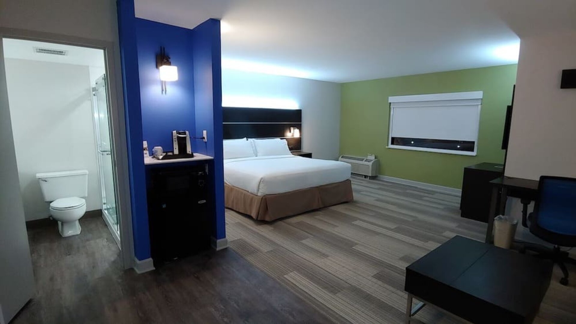 Spacious guest room featuring a king bed, a kitchenette area, a walk-in shower, and an open-concept layout at Holiday Inn Express Rolling Meadows-Schaumburg.