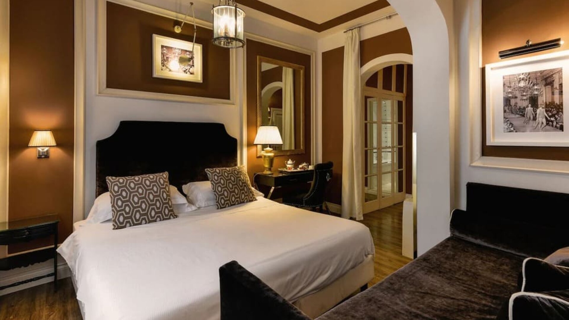 King room featuring a large bed, tall windows with sheer drapery, elegant lighting, and refined décor at Cellai Boutique Hotel.