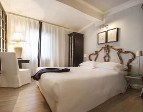 Day room featuring a plush bed, soft lighting, elegant furnishings, and a relaxing atmosphere at Cellai Boutique Hotel.