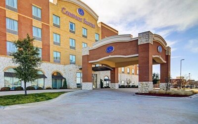 Exterior view of the hotel entrance with a covered porte-cochère and multi-storey façade at Comfort Suites Frisco.
