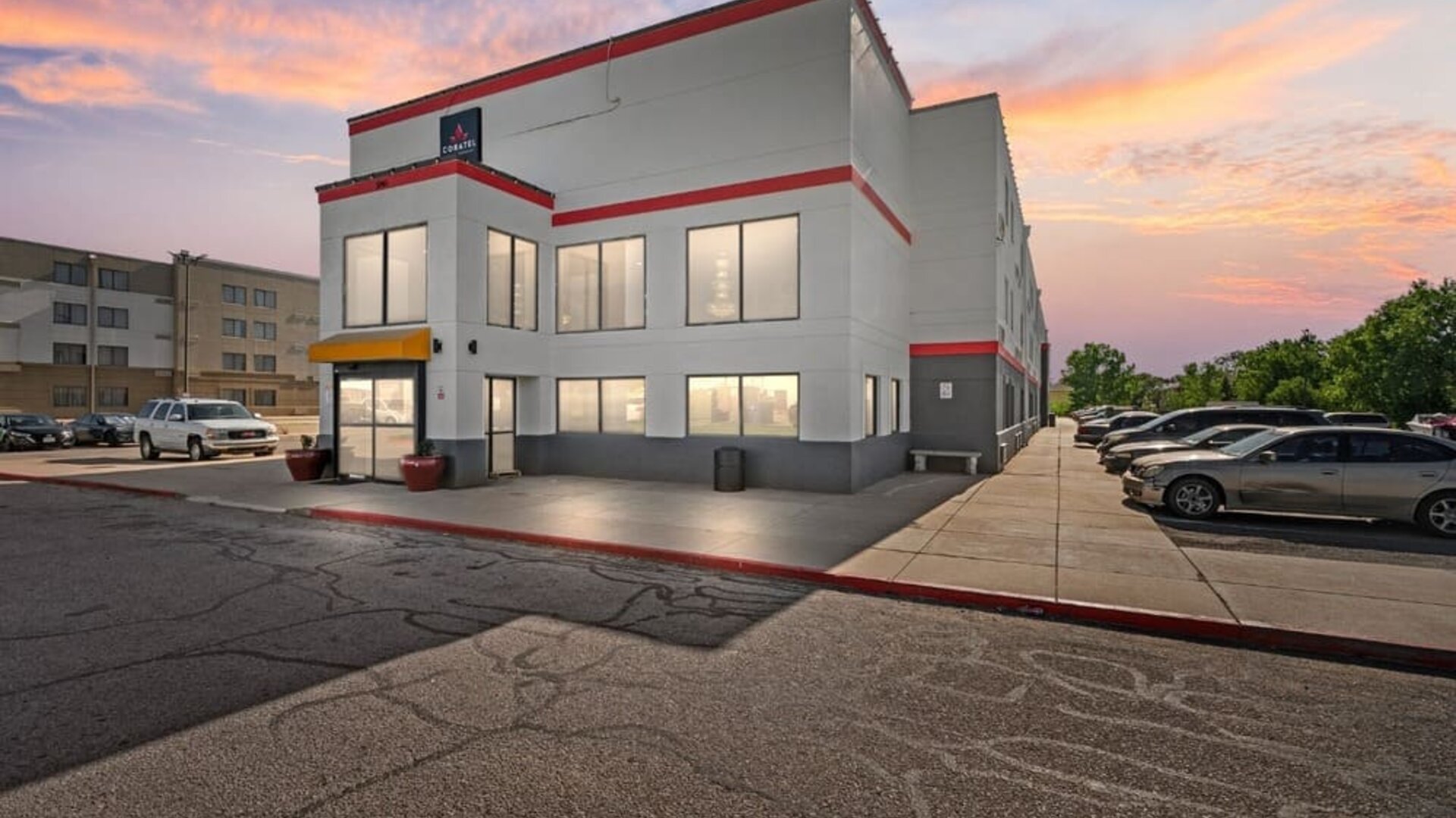 Exterior view of Coratel Inn And Suites By Jasper Wichita North with parking area.