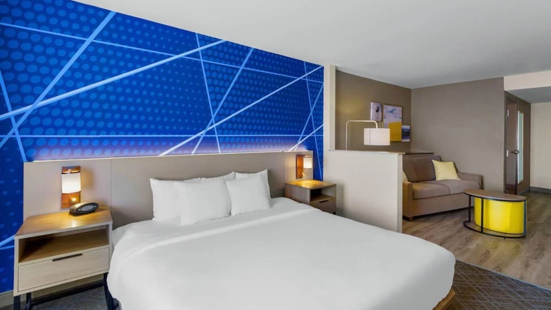 Spacious king suite featuring a king bed, separate sitting area with a sofa, and contemporary furnishings at Comfort Suites Vacaville-Napa Valley Area.