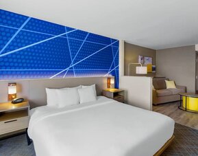Spacious king suite featuring a king bed, separate sitting area with a sofa, and contemporary furnishings at Comfort Suites Vacaville-Napa Valley Area.
