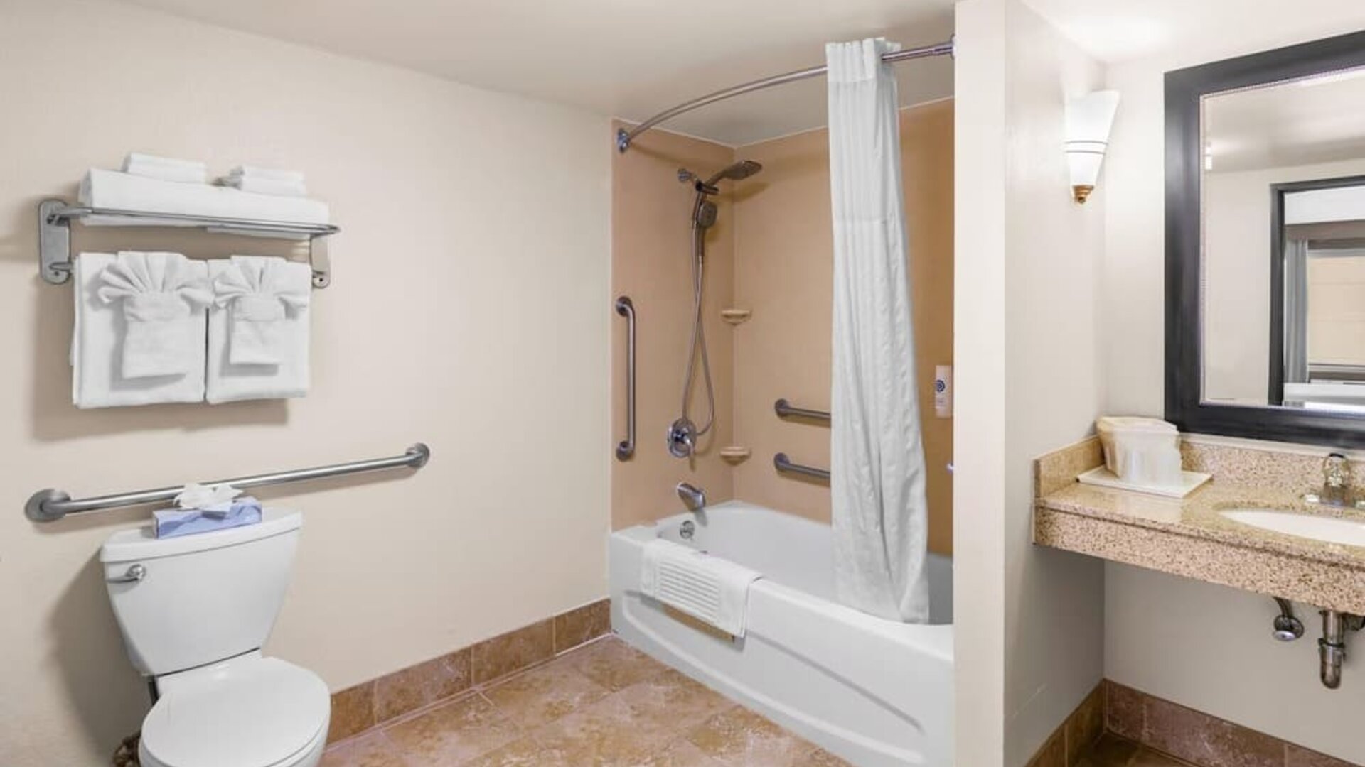 Accessible bathroom with a bathtub and shower combination, grab bars, spacious vanity, and fresh towels at Comfort Suites Vacaville-Napa Valley Area.