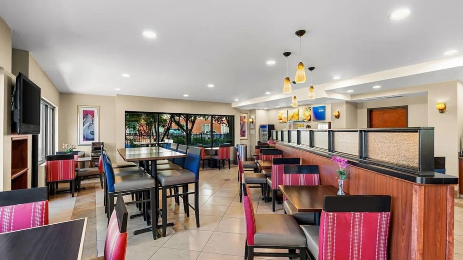 Bright dining and breakfast area with a variety of tables, comfortable seating, and large windows at Comfort Suites Vacaville-Napa Valley Area.